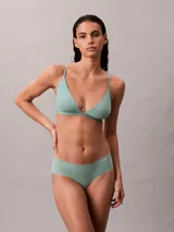 Bombacha tipo hipster de la línea invisible de Calvin Klein, confeccionada en microfibra ligera con bordes cortados a láser para un acabado sin costuras. Presenta un diseño de talle bajo con cobertura total en la parte trasera y el logo de la marca estampado en la cadera.