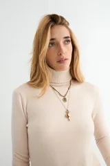 Polera de cuello alto y manga larga, confeccionada en tejido de punto fino con puños y ruedo acanalados.