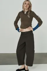 Pantalón cargo de tiro alto con corte holgado y diseño de volumen. Presenta bolsillos laterales tipo cargo, bolsillos frontales clásicos y cierre frontal con cremallera y botón.