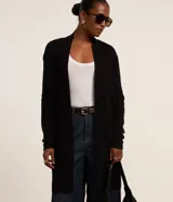 Cardigan alargado negro de punto, con diseño abierto al frente y bolsillos laterales.