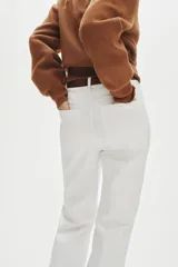 Pantalón acampanado de sarga de algodón color blanco, de tiro alto con pliegues en las piernas y bolsillos decorativos delanteros. Incluye cinturón marrón.