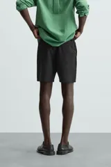 Bermuda de algodón color beige claro, de corte regular fit, con cintura elástica ajustable mediante cordón. Presenta bolsillos laterales y un bolsillo trasero de vivo.