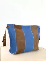 Sobre tipo bandolera de gamuza en franjas verticales alternadas de color azul y marrón, con costuras visibles y detalles de borlas colgantes.