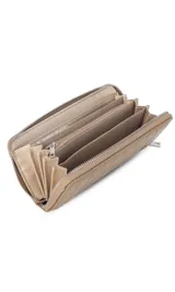 Billetera de dama en símil cuero color negro, de diseño acolchado con costuras verticales que forman relieves y cierre perimetral. Incluye monograma en la esquina inferior y viene con caja de presentación estampada.