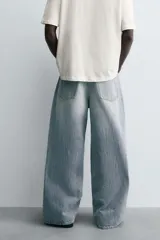 Jeans de denim de algodón, color azul oscuro con efecto lavado. Presentan un corte muy holgado (baggy fit) en toda la pierna y tiro medio. Tienen cinco bolsillos y cierre frontal con cremallera y botón.