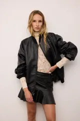 Campera bomber estilo retro de cuero vacuno, con corte oversized y diseño bombé. Presenta cierre frontal, bolsillos laterales y terminaciones de puños, cuello y pretina en tejido de algodón. Cuenta con forro interior de algodón.