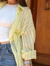 Camisa oversize a rayas de manga larga, con cuello camisero y cierre frontal de botones.