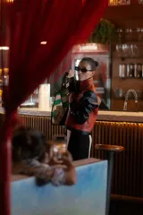 Chaqueta con cuerpo de cuero sintético rojo con estampado de piel de serpiente y mangas largas de cuero sintético negro.