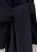 Camiseta azul marino de manga corta y cuello redondo, con diseño recto y detalle cruzado en el frente que forma un lazo lateral.