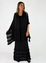 Pollera larga de punto color negro, con diseño ajustado en la parte superior y detalles de volados con textura en el ruedo.