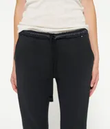 Pantalón de jogging negro, corto y entallado, con cintura elástica de satén con cordón, bolsillos laterales y puños elásticos en los tobillos.