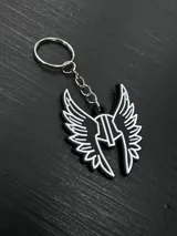 Llavero con dije de metal negro con forma de casco alado, con detalles en blanco. Incluye aro y cadena metálica plateada.