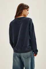 Buzo de cuello redondo y manga larga, en color azul oscuro con efecto lavado. Presenta un estampado frontal con la palabra 'HAPPY' repetida en un degradado de colores vibrantes.