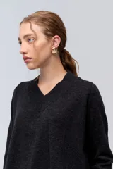 Sweater de tejido de punto color beige, con escote en V y calce holgado.