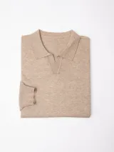 Buzo tejido de punto color beige, con cuello polo y escote en V profundo, de manga larga con puños acanalados.