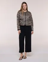 Campera puffer corta de diseño reversible y liviano, marca Michael Kors. Cuenta con acabado resistente al agua, diseño acolchado con matelaseado horizontal, cuello redondo a la base sin solapa ni capucha, cierre frontal completo con botones de presión metálicos, bolsillos laterales funcionales y ribetes a tono. Largo a la cintura y empacable en su propia bolsa de guardado.