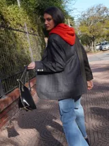 Blazer oversize bicolor de la marca Agnés, con diseño de doble faz que combina un lado en tejido gris oscuro liso y otro lado en tejido tostado con patrón de rayas diplomáticas. Cuenta con solapas clásicas, cierre frontal de dos botones y bolsillos aplicados.