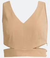 Blusa corta color beige con escote en pico y tirantes anchos. Presenta un recorte en la cintura.