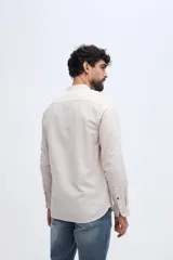 Camisa de lino y algodón color celeste, con cuello mao, cierre frontal de botones claros y pequeño bordado de pato en el pecho.