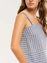 Musculosa de lino a rayas verticales azules y blancas, con breteles anchos y ruedo con flecos.