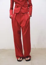 Pantalón de vestir rojo de corte wide leg, tiro alto y detalle de pliegues.
