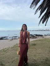 Top de tejido de punto color ladrillo, con escote profundo tipo halter, espalda descubierta y cierre frontal con cordones ajustables.