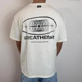 Remera negra de corte regular con estampa gráfica en la espalda que incluye un diseño circular abstracto y el texto BREATHEfast.