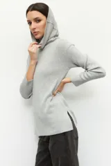 Polera color beige de cuello alto extendible, manga larga y pequeñas aberturas en los laterales.