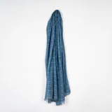 Pashmina de textura ligera y semitransparente, color azul con diseño de cuadrícula sutil y bordes desflecados.