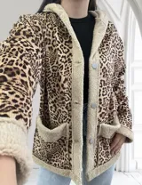 Campera con capucha de pana con estampado animal print y forro de piel sintética color crema. Tiene bolsillos delanteros y cierre con botones a presión plateados.