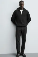 Pantalón chino de corte ajustado, color beige, con bolsillos laterales y bolsillos traseros de vivo. Cuenta con cierre frontal de cremallera y botón.
