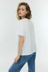 Remera blanca de corte holgado, con cuello redondo y mangas cortas. Confeccionada en tejido de punto suave.