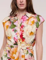 Vestido midi de calce fluido y corte camisero, con estampado floral en tonos rosa, rojo, amarillo y verde. Cuenta con cuello camisero, escote en V, abotonadura frontal oculta, mangas cortas tipo cap sleeve, lazo ajustable en la cintura del mismo género y falda evasé con recorte fruncido.