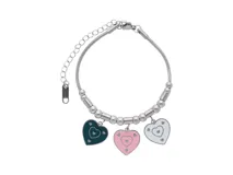Pulsera de acero plateado con eslabones de cadena y cuentas. Incluye tres dijes esmaltados en forma de corazón: uno turquesa, uno rosa y uno blanco.