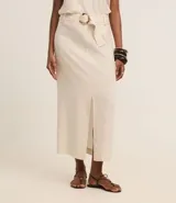 Pollera midi color blanco hueso, de corte recto con tajo frontal. Confeccionada en viscolino, presenta un cinturón con hebilla redonda y detalles de pespuntes y encaje en la parte delantera.