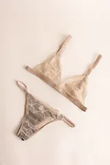 Sostén tipo bralette negro de encaje elastizado, con diseño triangular y breteles con detalle de encaje.