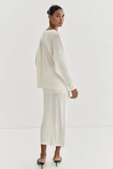 Jersey de punto fino con diseño oversize, cuello redondo y manga larga.