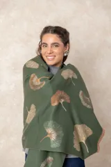 Pashmina reversible de textura suave y caída fluida, con diseño estampado de hojas de ginkgo biloba. Presenta un lado con fondo oscuro y otro con fondo claro, finalizando en ambos extremos con flecos cortos deshilachados.
