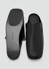 Zapatos tipo mule de piel ovino, color negro, diseño slip-on sin cierre, punta cuadrada y suela plana.