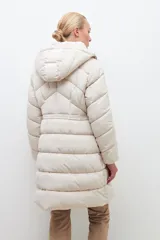 Campera puffer de corte largo y diseño capitoneado, con capucha desmontable y cierre frontal completo. Presenta bolsillos laterales con cierre y puños elásticos.