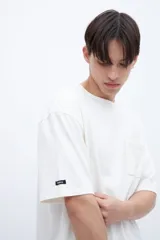 Remera color crudo de algodón con calce oversize, manga corta, cuello redondo y estampa en la espalda con texto en color negro.