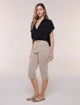 Pantalón capri blanco de tiro alto, corte entallado y silueta ajustada, con pretina ancha elastizada sin cierres, bolsillos simulados al frente y pequeños tajos en los ruedos.