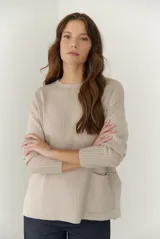 Buzo de tejido de punto acanalado en color beige, con cuello redondo, mangas largas y un bolsillo frontal aplicado en la parte inferior.