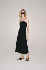 Vestido midi negro confeccionado en mezcla de viscosa, con escote palabra de honor, hombros descubiertos, corte evasé y cierre lateral con cremallera oculta.
