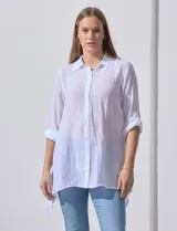 Camisa larga de rayón, con cuello camisero, cierre frontal de botones y mangas con presilla para regular el largo. Presenta un corte holgado con tajos laterales en el ruedo.
