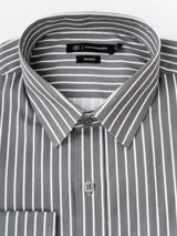 Camisa de manga larga con cuello clásico y cierre frontal de botones. Presenta un diseño de rayas verticales blancas sobre fondo gris oscuro. La prenda cuenta con una etiqueta de marca Cuatro Ases en el interior del cuello.