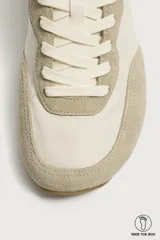 Zapatilla deportiva barefoot de hombre, confeccionada en combinación de piezas de piel con acabado serraje en color marrón, con cordones y suela fina de goma en contraste.