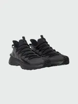 Championes Moncler modelo Trailgrip Lite2 de color negro, diseñados para trekking y actividades al aire libre. Presentan una silueta robusta, suela dentada Vibram, cordones redondos gruesos, tiradores en la lengüeta y el talón, y el nombre de la marca grabado en el lateral.