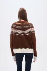 Sweater de poliéster color verde oliva con diseño geométrico en blanco, beige y marrón. Tiene cuello redondo, corte al cuerpo y detalles de cuentas en el cuello.