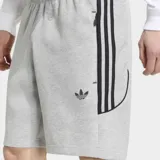 Short Adidas Spacer Teamgeist 26 Cutline color gris, con cintura elástica y cordón de ajuste. Presenta el logo del Trifolio bordado en una pierna y líneas laterales icónicas inspiradas en el fútbol con detalles gráficos.